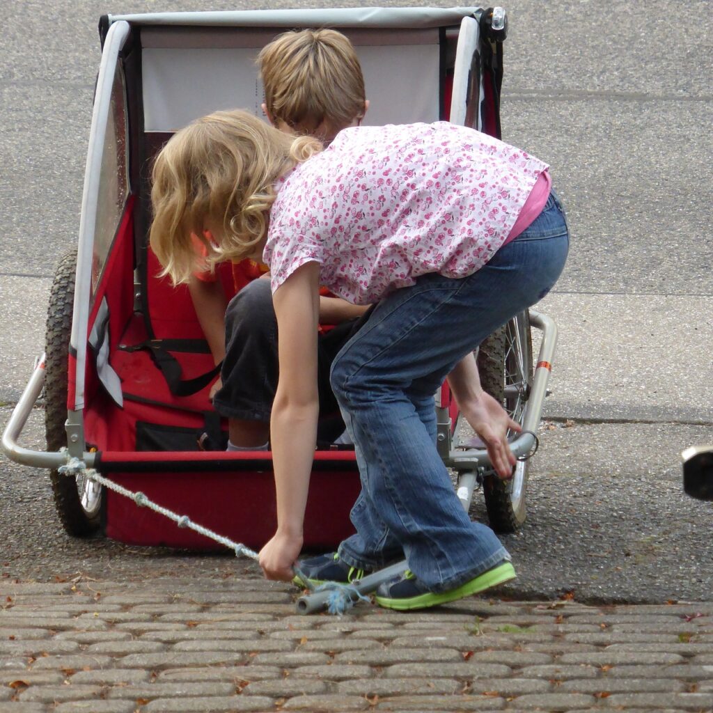 Kinder nutzen Fahrradanhänger zum Spielen