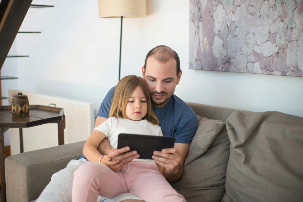 Vater und Tochter lernen Umgang mit digitale Medien