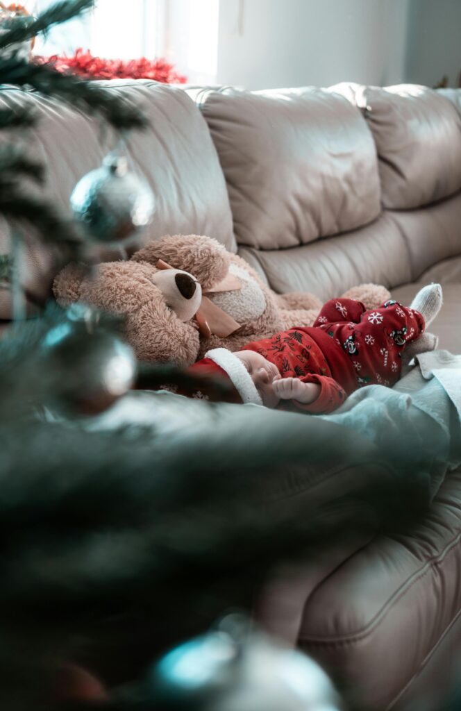 Baby schläft bei Weihnachten mit Baby unterm Tannenbaum