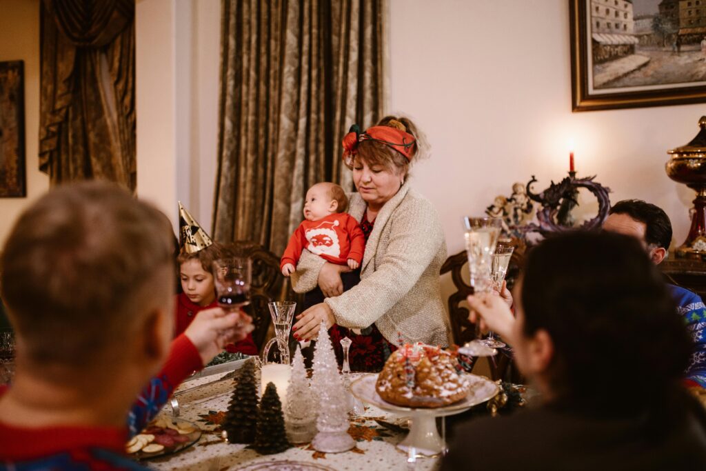 Oma hält bei Weihnachten mit Baby ddas Kind im Arm